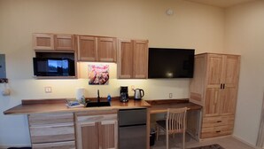 A compact kitchen with wooden cabinets, a microwave, a coffee maker, and a dishwasher. - GLACIER SUITE, BEACH WALK INN, UPPER LEVEL UNIT
FEATURING HOMER'S FANTASTIC VIEW (Homer)