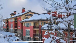 Un hotel de varios pisos con balcones y un paisaje cubierto de nieve.
