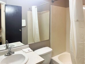 Een bad/douchecombinatie, handdoeken