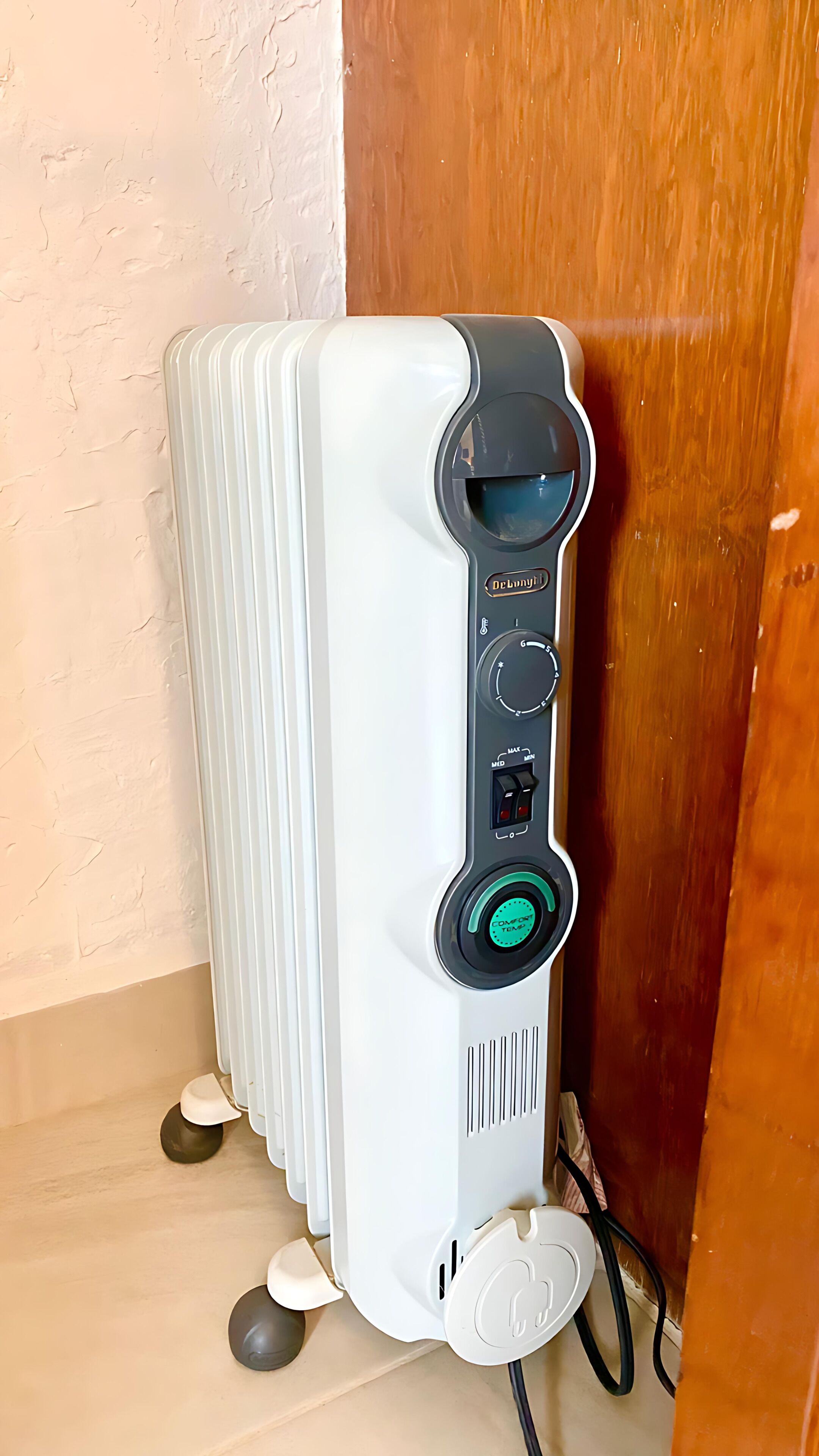 A white portable heater with a digital control panel, a power cord, and a safety lock.