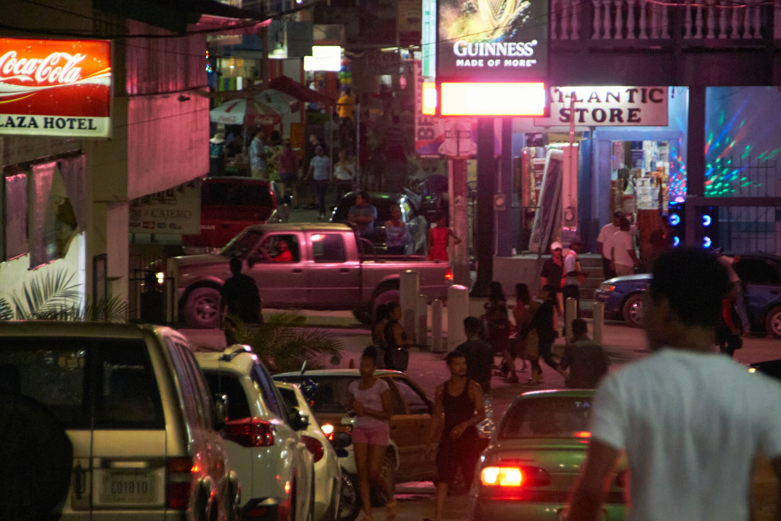 Escena de carrer animada amb diverses botigues, incloent un cartell de Coca-Cola i un cartell de Guinness.