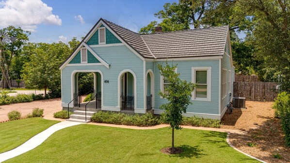 A single-story house with a gabled roof, a front porch with a staircase, and a small front yard. - Eskew Place | 3 blocks to Main | Newly Renovated (Fredericksburg)