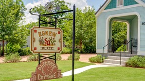 Un panneau indiquant « Eskew Place », avec un design rustique, une horloge et un symbole représentant une maison de campagne.