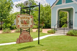 A sign for 'Eskew Place' with a rustic design, a clock, and a cottage symbol. - Alphonse Cottage | 3 blocks to Main | Cute & Cozy (Fredericksburg)