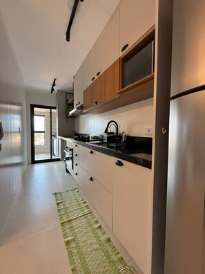 Fridge, microwave, oven, stovetop - Beachfront apartment with ocean view. (Maracanã Praia Grande)