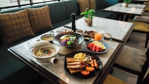 A dining area with tables set for breakfast, including plates of eggs, toast, and fruit.