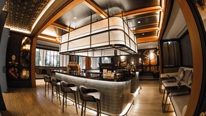 A modern bar area with a curved counter, bar stools, and a seating area with a sofa and a coffee table.