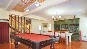A pool table in a room with a staircase, dining table, chairs, and a cabinet with glass doors. - Relax in a 5-bedroom villa with a private pool in Vilamoura. (Vilamoura)