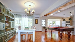 A spacious room with a pool table, a dining area with chairs, and a kitchen area with appliances. - Relax in a 5-bedroom villa with a private pool in Vilamoura. (Vilamoura)