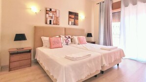 A double bed with white linens and pink pillows, a nightstand with a lamp, and artwork on the walls. - Relax in a 5-bedroom villa with a private pool in Vilamoura. (Vilamoura)