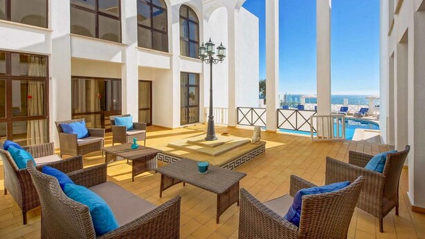 A spacious outdoor area with wicker furniture, a pool, and a view of the sea. - Relax by the pool at Villa Mar, minutes from Sao Rafael’s beaches (Sao Rafael)
