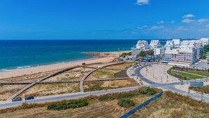 Eine Küstenstadtlandschaft mit Strand, Straße und modernen Gebäuden.