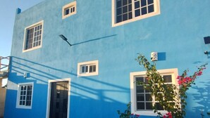 A two-story building with a blue exterior and white window frames. - Casa La Paz  (Merida)