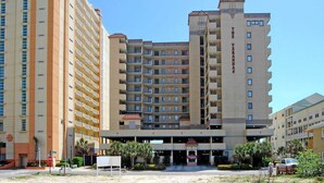 Un hôtel à plusieurs étages, doté d’une entrée principale, de nombreux balcons et d’une enseigne indiquant « The Verandas ».