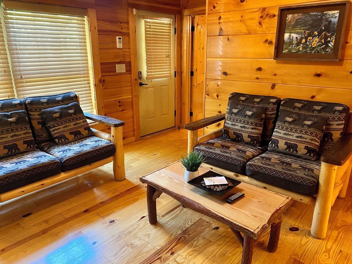A wooden interior with two sofas and a coffee table, featuring animal-themed cushions.