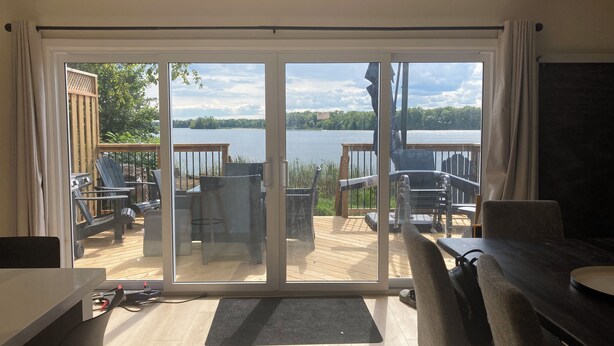 Ein Zimmer mit einer Schiebet ür und Zugang zu einer Terrasse mit Seeblick.