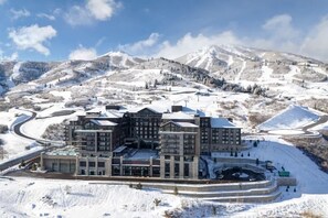 A multi-story hotel with a central courtyard, surrounded by snow-covered hills and a ski resort. - Abode at Deer Valley East, hot tub, pool, resort access, Deer Valley (Park City)