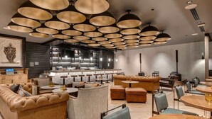 Ein modernes Interieur mit Bar, Ledersitzmöbeln und Pendelleuchten.