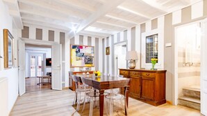 Une cuisine spacieuse avec une table et des chaises en bois, un buffet et un tableau accroché au mur.
