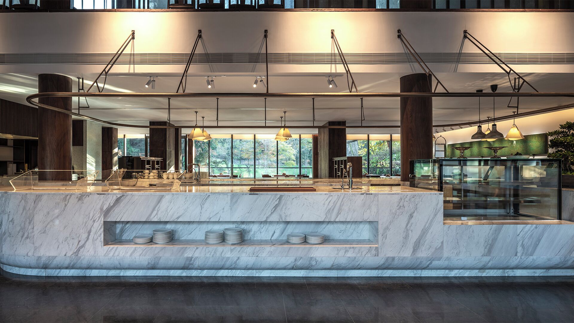 Una cocina moderna con encimeras de mármol, iluminación colgante y vistas al exterior.