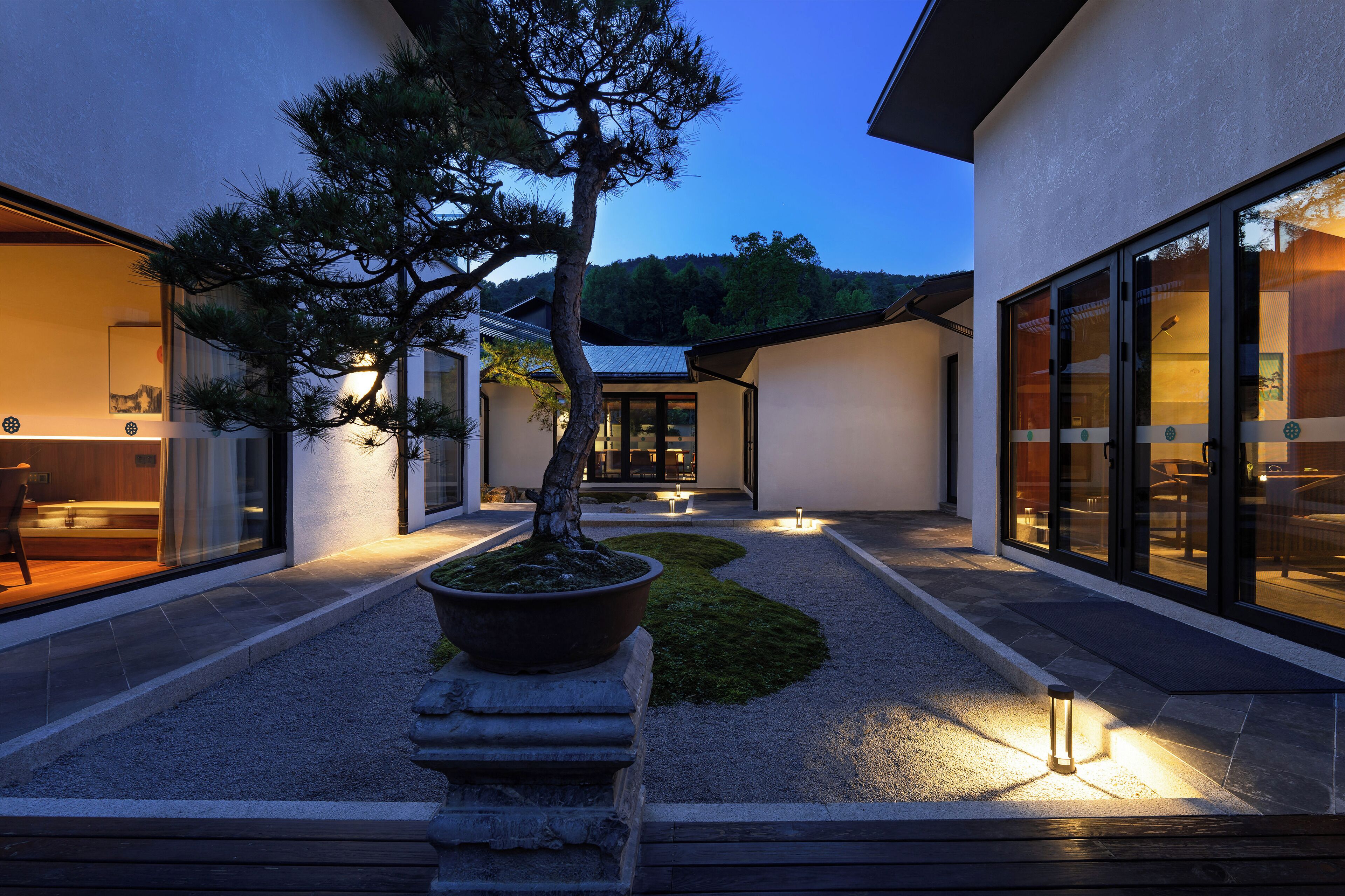 A modern building with a well-maintained garden, large windows, and a visible entrance.