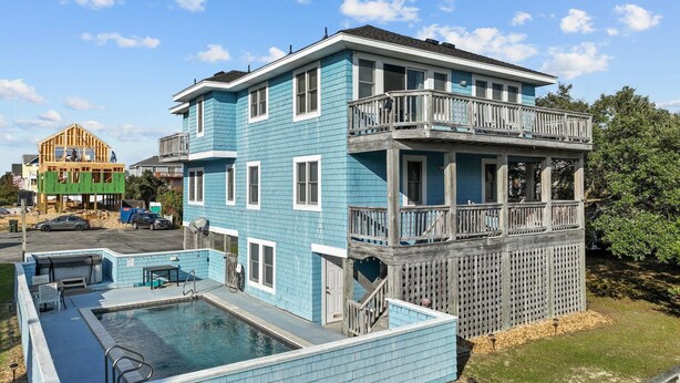 A two-story building with a pool and a balcony. - 1750 - Cool Winds, Corolla Beach House: Private Pool & Hot Tub (Corolla)