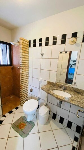 Ein Badezimmer mit Toilette, Waschbecken und Dusche.