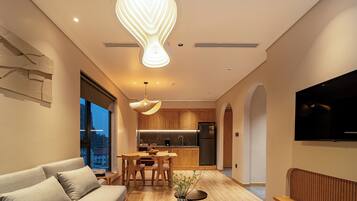 Una cocina moderna con armarios de madera, horno empotrado y refrigerador de acero inoxidable.