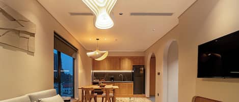Una cocina moderna con armarios de madera, horno empotrado y refrigerador de acero inoxidable.