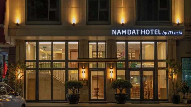 A hotel with a modern facade, large windows, and a sign reading "NAMDAT HOTEL by D'Lecia". - Nam Dat Hotel by D'Lecia Ha Long (Hong Gai)