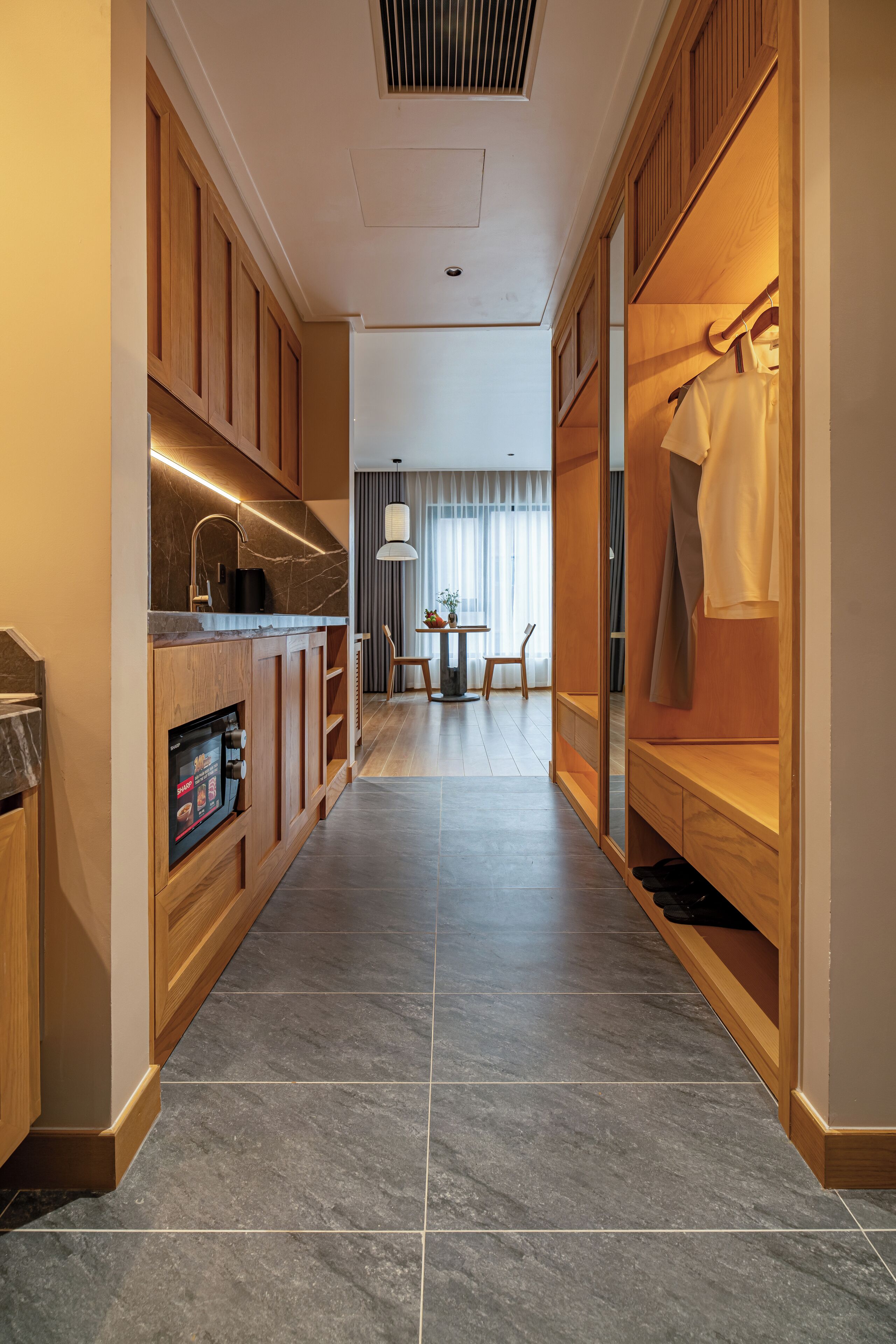 A modern kitchen with wooden cabinets, a built-in dishwasher, and a dining area with a table and chairs.
