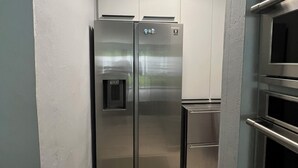 A compact kitchen with stainless steel appliances, including a refrigerator and oven, and a small countertop.