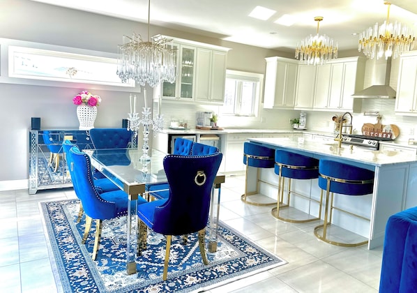 A modern kitchen with white cabinets, blue bar stools, and a central island. - Spacious 4-Bedroom Retreat next to Welland Waterpark – Perfect for Families!"
(Welland)