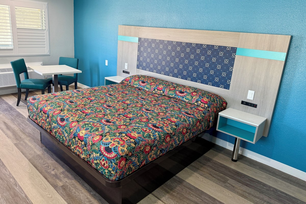 A bedroom with a bed, a desk, and a chair.