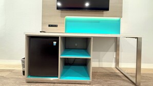 Un mueble moderno para entretenimiento con un televisor de pantalla plana montado sobre una zona de estar acolchada en color aguamarina.