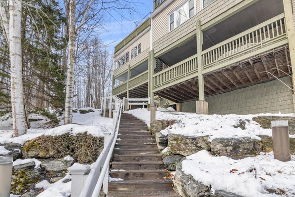 A multi-story building with a wooden staircase leading to a balcony.