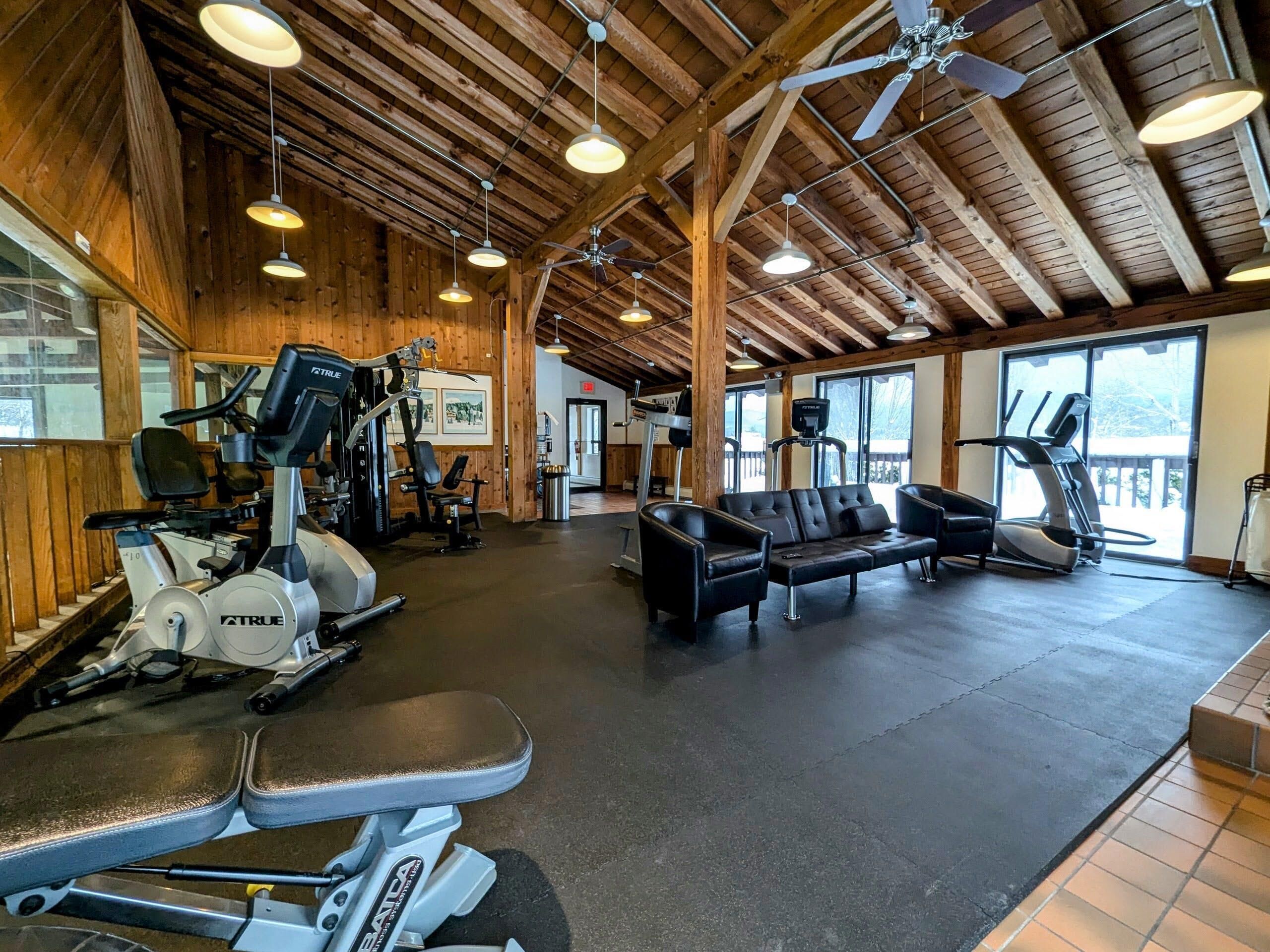 Une salle de sport équipée de matériel d’exercice, d’un tapis de course et d’un banc.