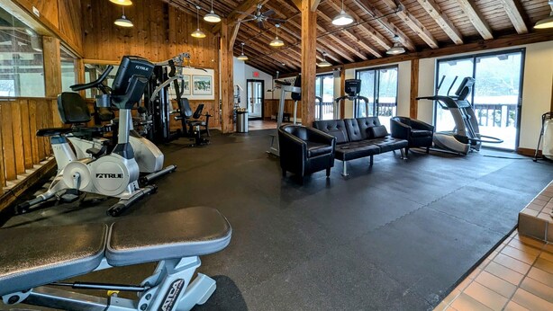A gym with exercise equipment, a treadmill, and a bench. - Charming Stay in Stowe Condo: Hot Tub&Indoor Pool (Stowe)