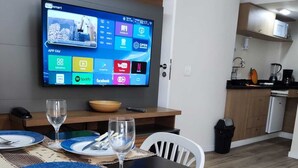 Eine moderne Küche mit einem an der Wand montierten Flachbildfernseher, der verschiedene Anwendungen anzeigt.