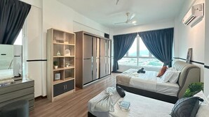 Ein Hotelzimmer mit zwei Betten, einem Schrank, einem Schreibtisch und einem großen Fenster mit Vorhängen.