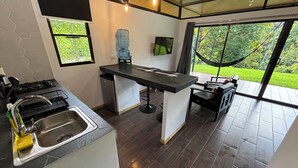 Una cocina moderna con estufa integrada, pileta y un amplio dispensador de agua.