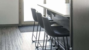 A room with a large window, a table, and four chairs. - Elk Horn Cabin Rental - Pet Friendly! (Valemount)