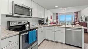 A modern kitchen with white cabinets, a built-in microwave, a stove, and a dishwasher. - Oceanfront- 2BR  2BA  beautiful condo in the heart of Myrtle Beach (Myrtle Beach)