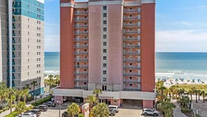 A multi-story hotel with a central atrium, located near a beach with visible ocean views. - Oceanfront- 2BR  2BA  beautiful condo in the heart of Myrtle Beach (Myrtle Beach)