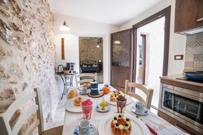 A dining area with a table set for breakfast, a coffee machine, and a view of the kitchen. - San Giorgio Boutique Apt1 With Airco, Martano, Italy (Martano)