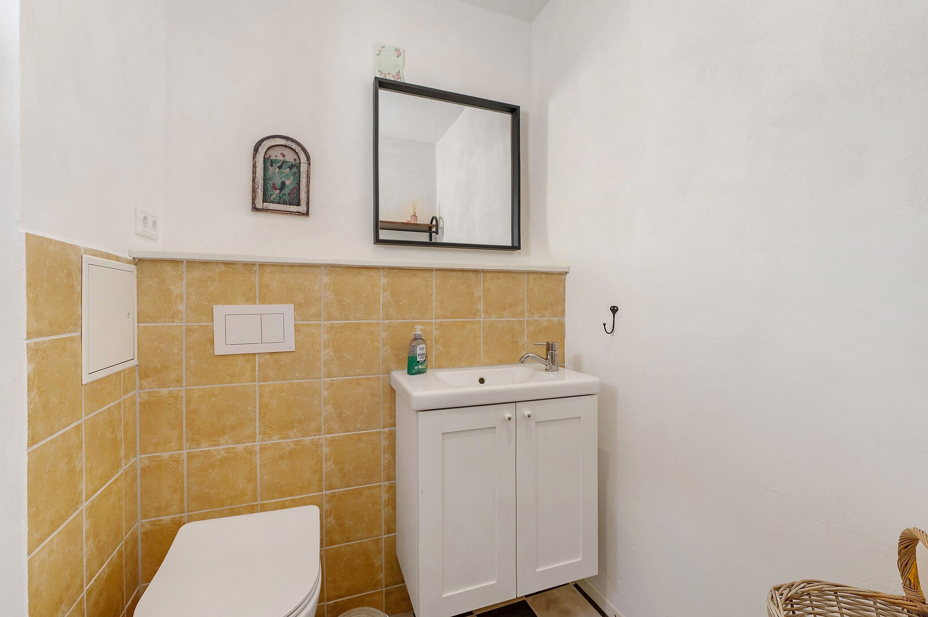 Une salle de bain avec des toilettes, un lavabo et un miroir.