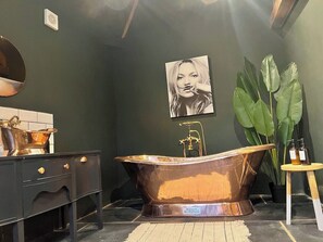 A bathroom with a freestanding bathtub, a sink with a mirror, and a potted plant. - Torworth - 1 Bed Barn - Sleeps 3 - Hot Tub (Torworth)