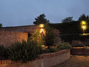 A brick wall with a small tree and a brick planter with greenery. - Torworth - 1 Bed Barn - Sleeps 3 - Hot Tub (Torworth)