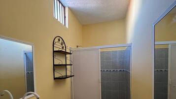 Chuveiro, toalhas de banho, sabonete, papel higiênico