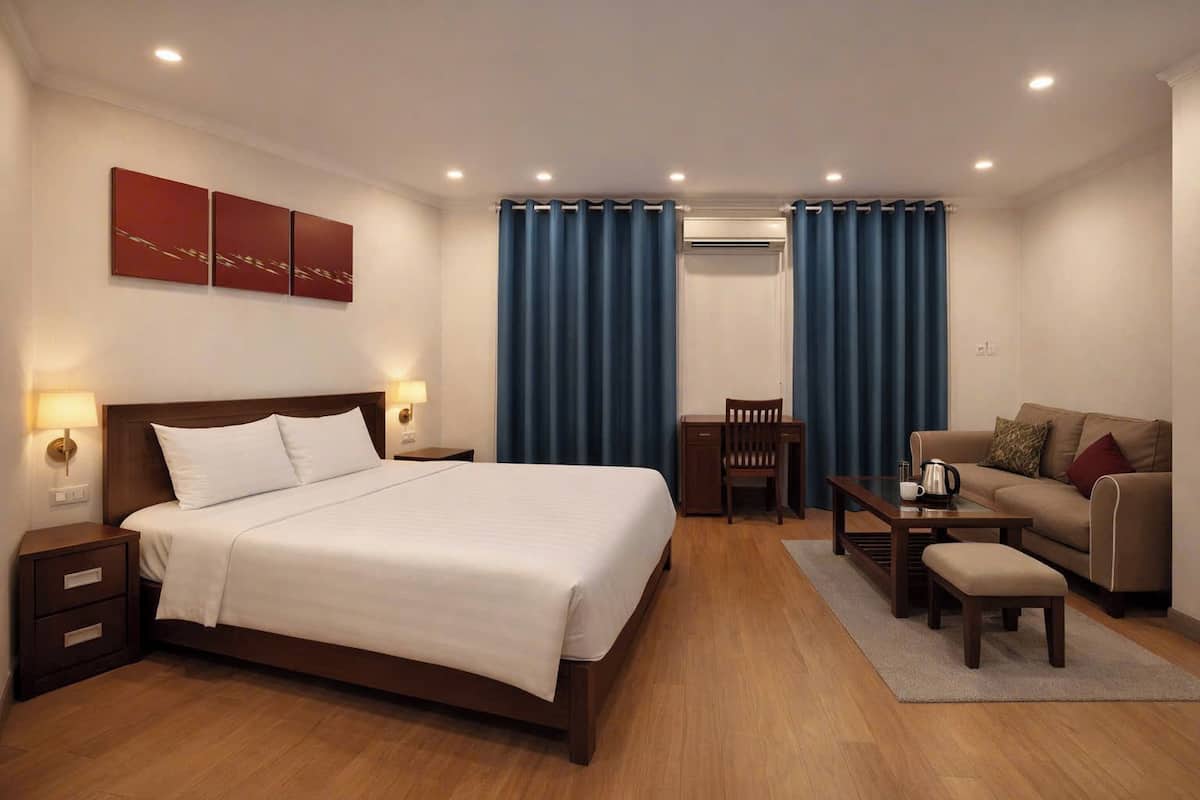 Une chambre d’hôtel avec un lit, un bureau, un canapé et une table basse.